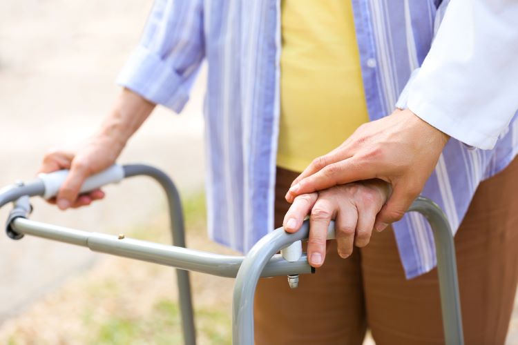 elderly woman with walker assisted by aging life care manager